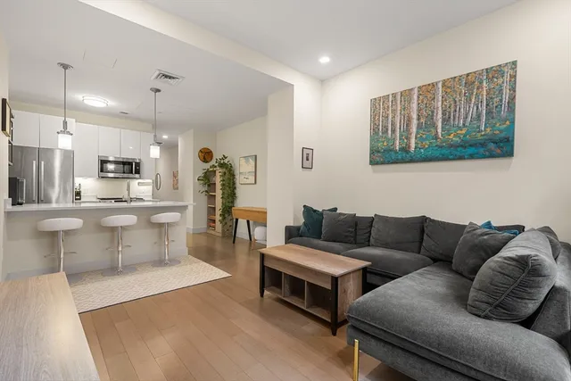 a living room with furniture and kitchen view