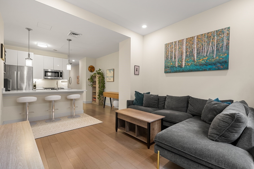 121-127 Portland Street, Unit 307 Boston, MA 02114 - Photo 2 of 27 a living room with furniture and kitchen view