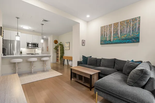 a living room with furniture and kitchen view