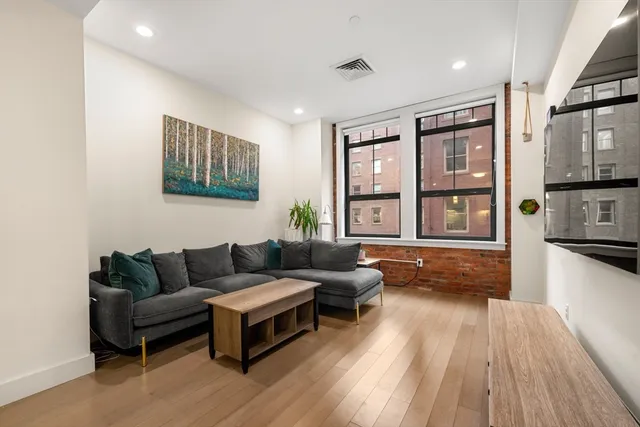 a living room with furniture and a wooden floor