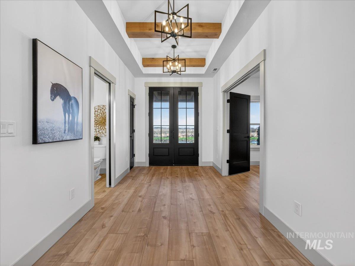 2240 Little Rock Road Emmett, ID 83617 - Photo 11 of 50 Foyer entrance with beam ceiling, light wood-style floors, french doors, and a chandelier