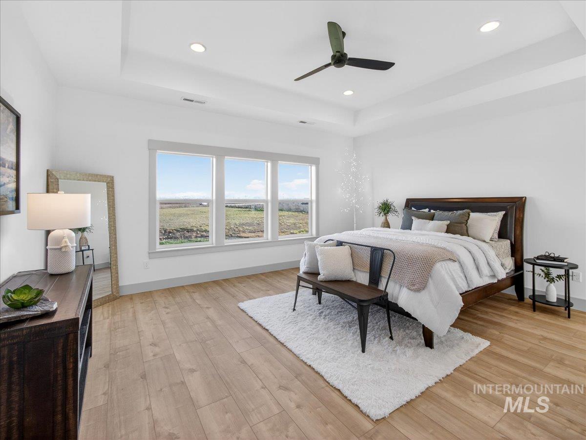 2240 Little Rock Road Emmett, ID 83617 - Photo 25 of 50 Bedroom with a tray ceiling, light wood finished floors, ceiling fan, and recessed lighting