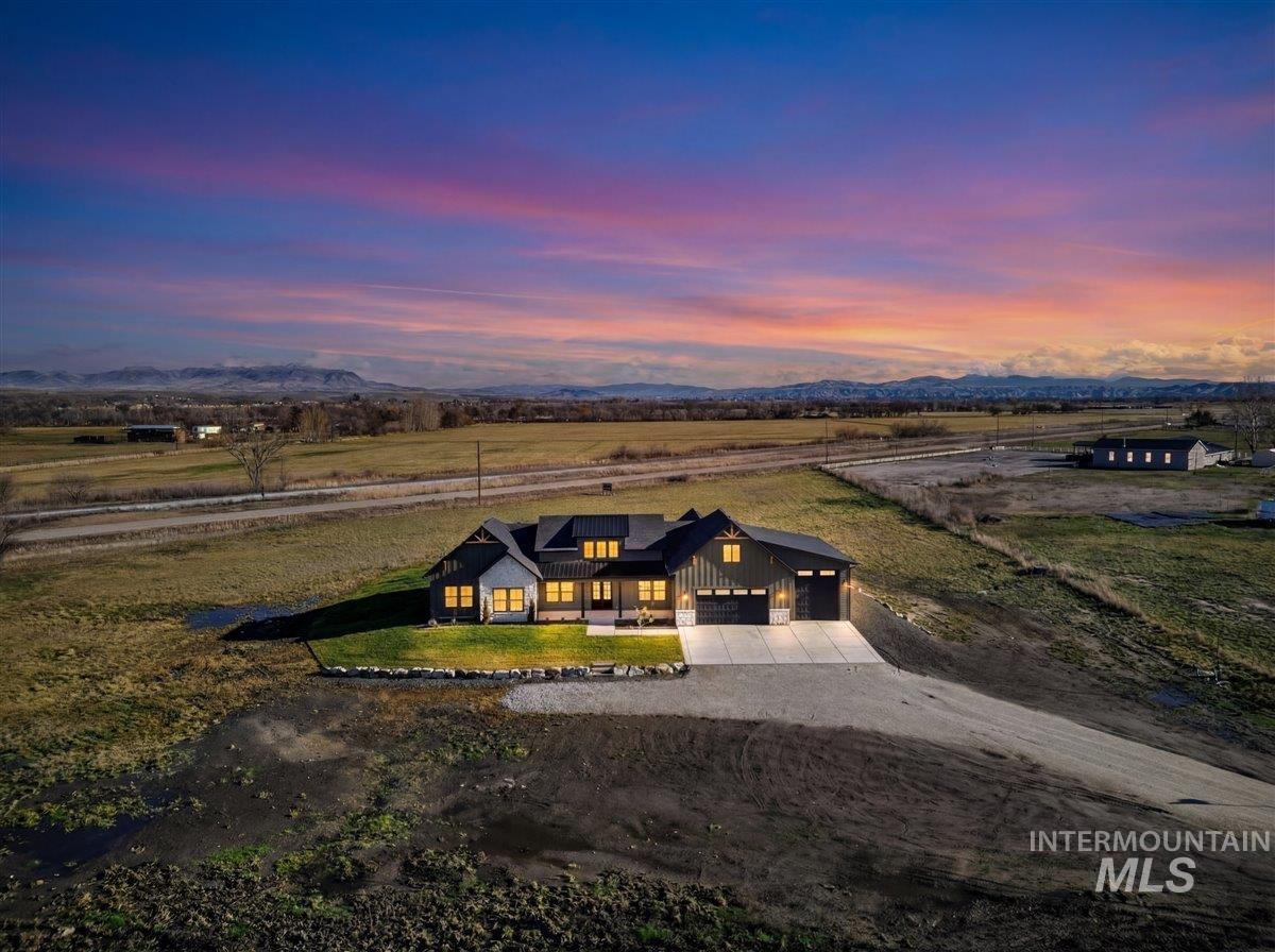 2240 Little Rock Road Emmett, ID 83617 - Photo 3 of 50 View of front of home featuring driveway, board and batten siding, a front yard, a mountain view, and a garage