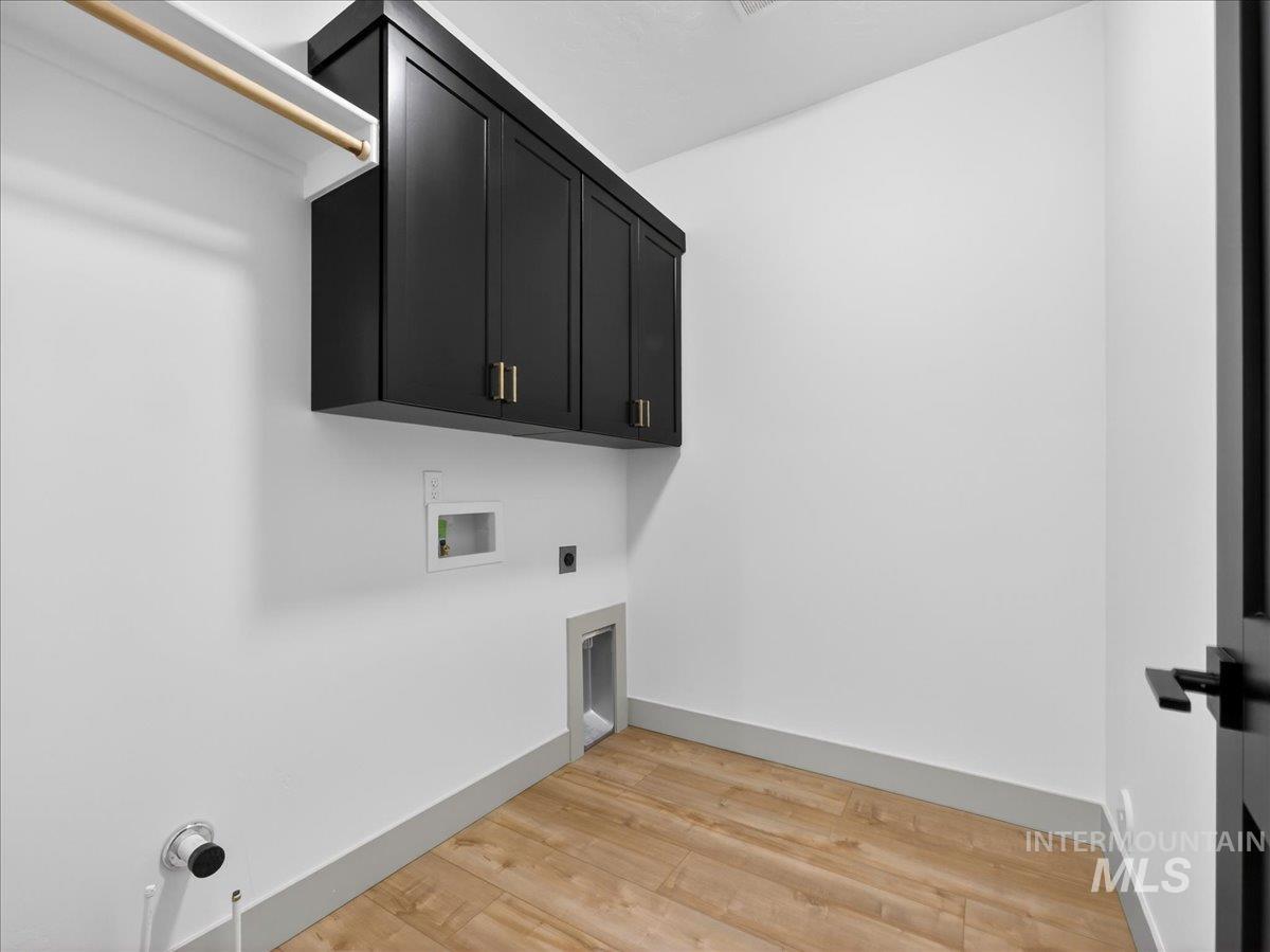 2240 Little Rock Road Emmett, ID 83617 - Photo 35 of 50 Washroom with cabinet space, washer hookup, light wood-style floors, and electric dryer hookup