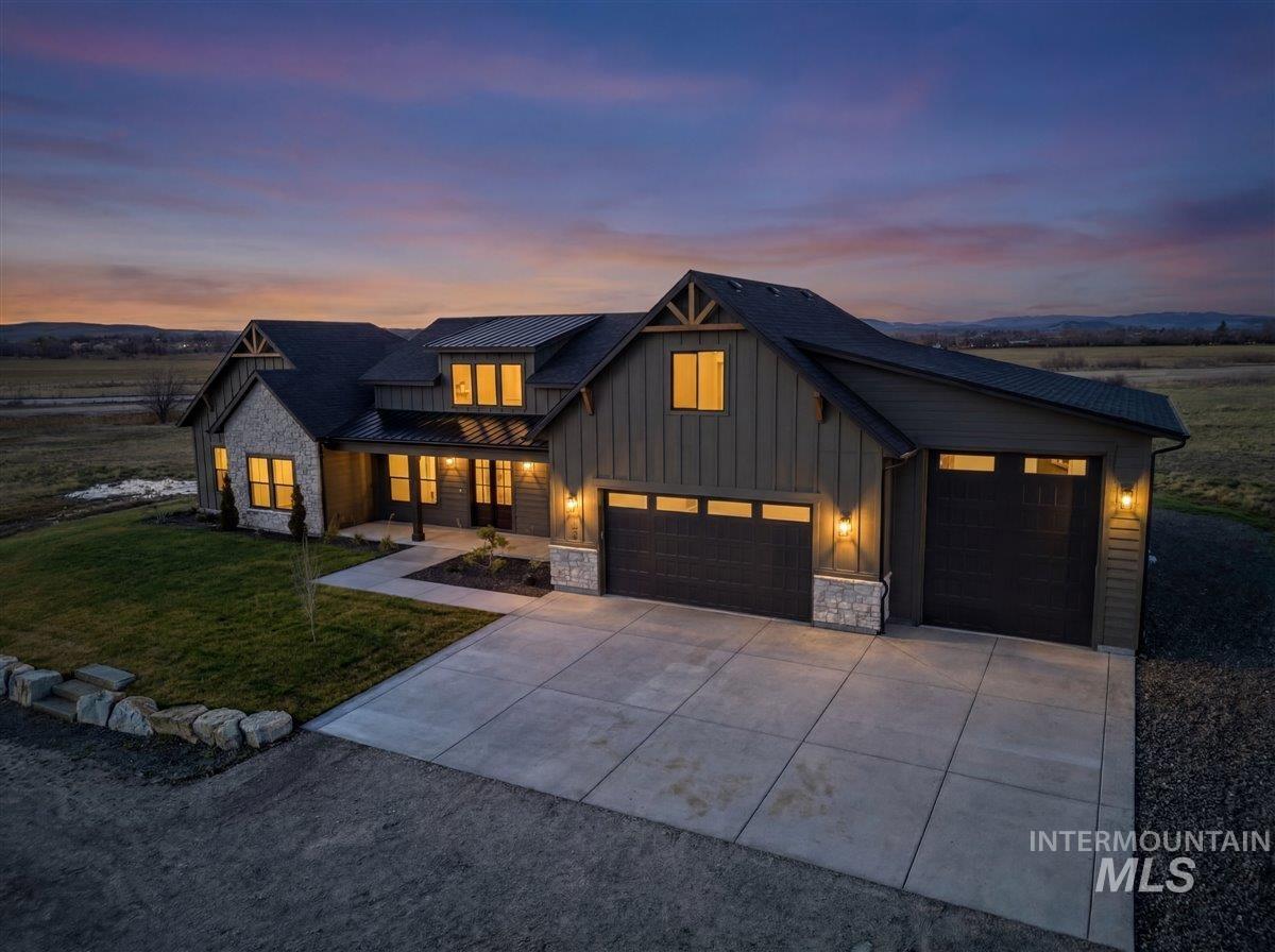 2240 Little Rock Road Emmett, ID 83617 - Photo 4 of 50 Modern inspired farmhouse featuring stone siding, covered porch, a lawn, board and batten siding, and concrete driveway