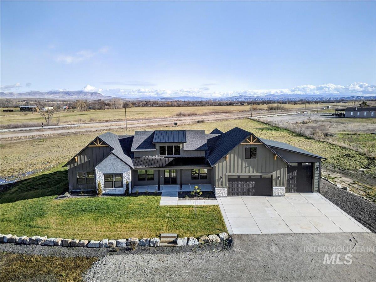 2240 Little Rock Road Emmett, ID 83617 - Photo 5 of 50 Modern inspired farmhouse with board and batten siding, covered porch, stone siding, and concrete driveway