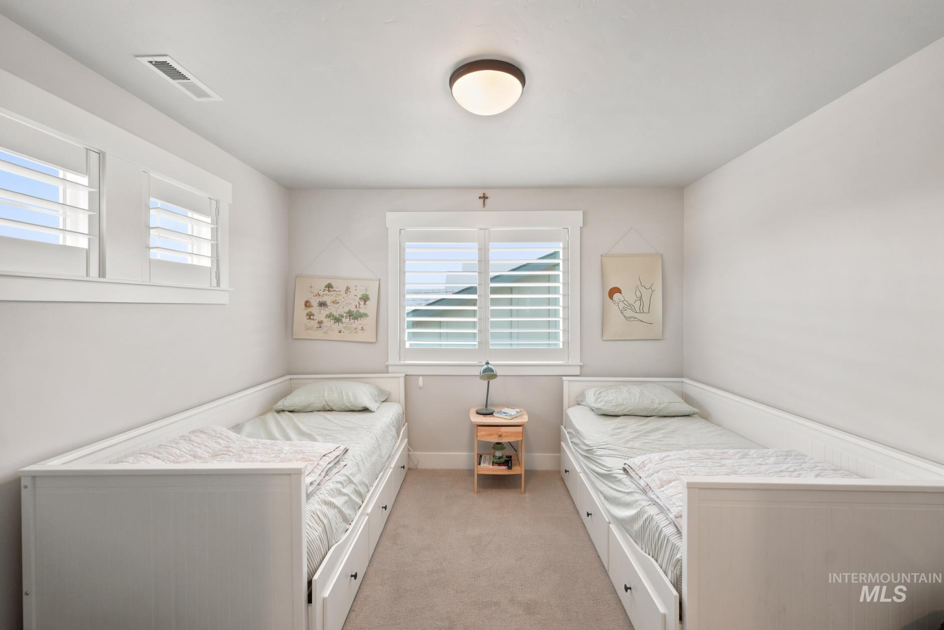 6933 South Zenith Avenue Meridian, ID 83642 - Photo 15 of 34 Room featuring two single beds with integrated under-bed storage drawers, white window frames, and horizontal slatted window coverings