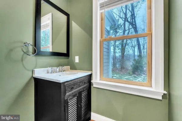 a bathroom with a sink a mirror and a window