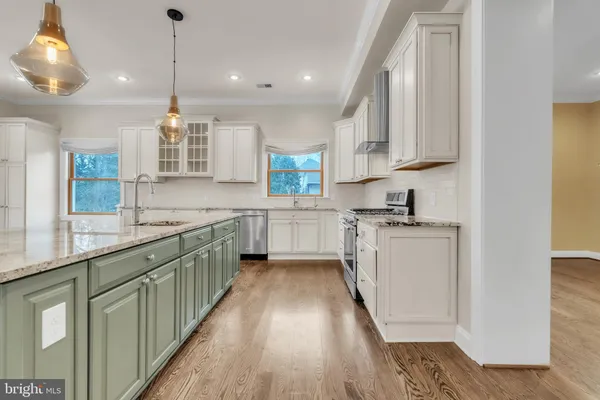 a kitchen with counter top space a sink wooden floor and stainless steel appliances