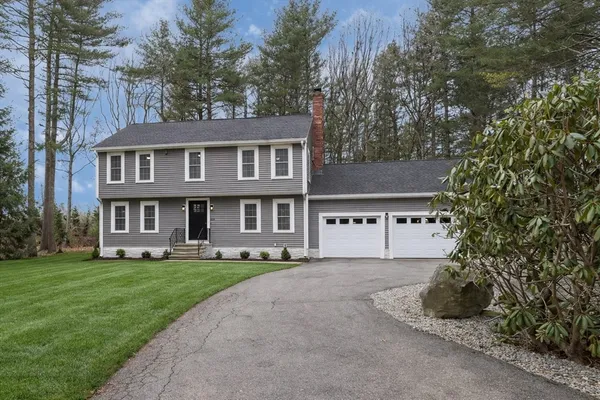 a view of a house with a yard and large tree