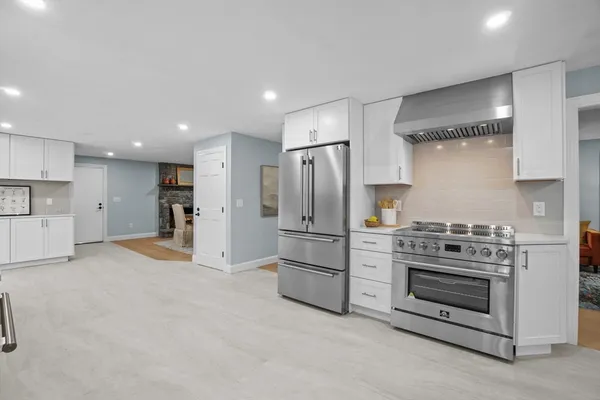 a kitchen with white cabinets and window