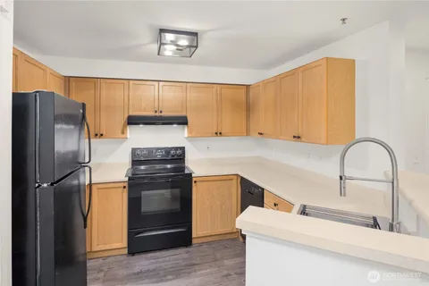 a kitchen with stainless steel appliances granite countertop a sink and a white cabinets