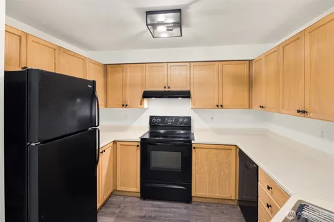 an empty room with windows and fireplace