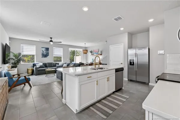 a large white kitchen with lots of counter space and stainless steel appliances