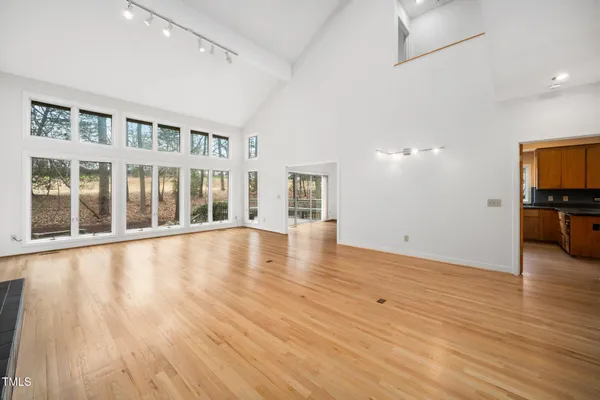a view of empty room with wooden floor and a window