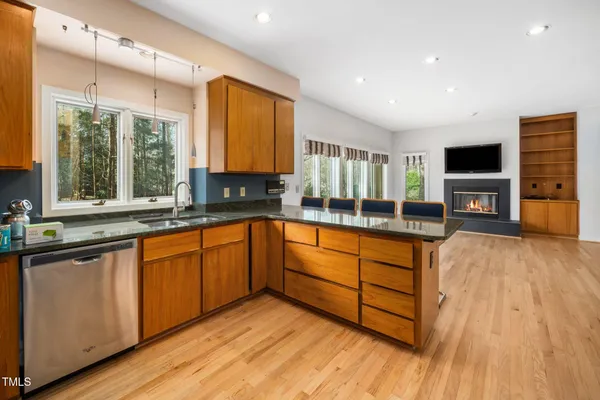 a large kitchen with stainless steel appliances wooden floors and wooden cabinets