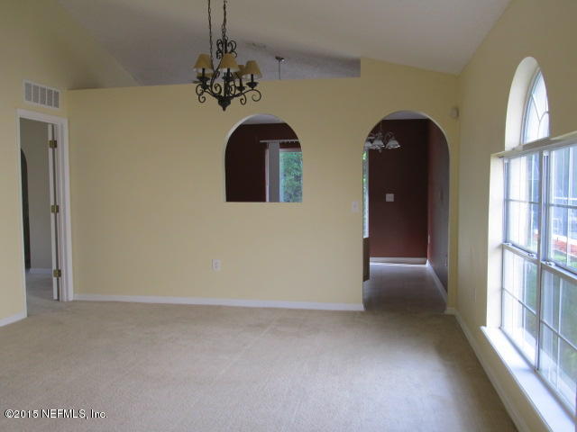 3488 Alec Drive Middleburg, FL 32068 - Photo 6 of 24 an empty room with windows and chandelier