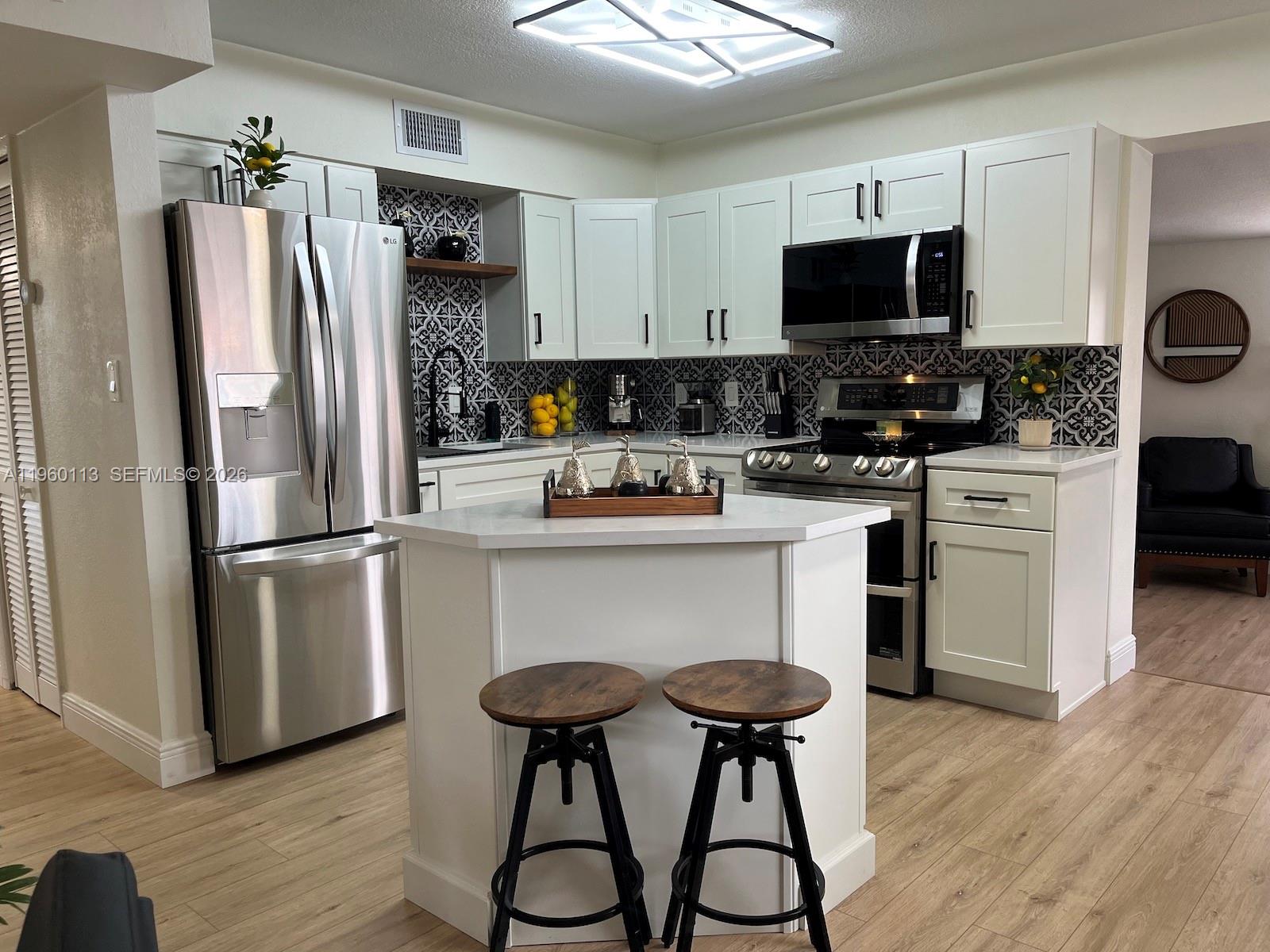 2253 Dordon Drive Melbourne, FL 32935 - Photo 19 of 40 a kitchen with stainless steel appliances a refrigerator stove microwave and cabinets