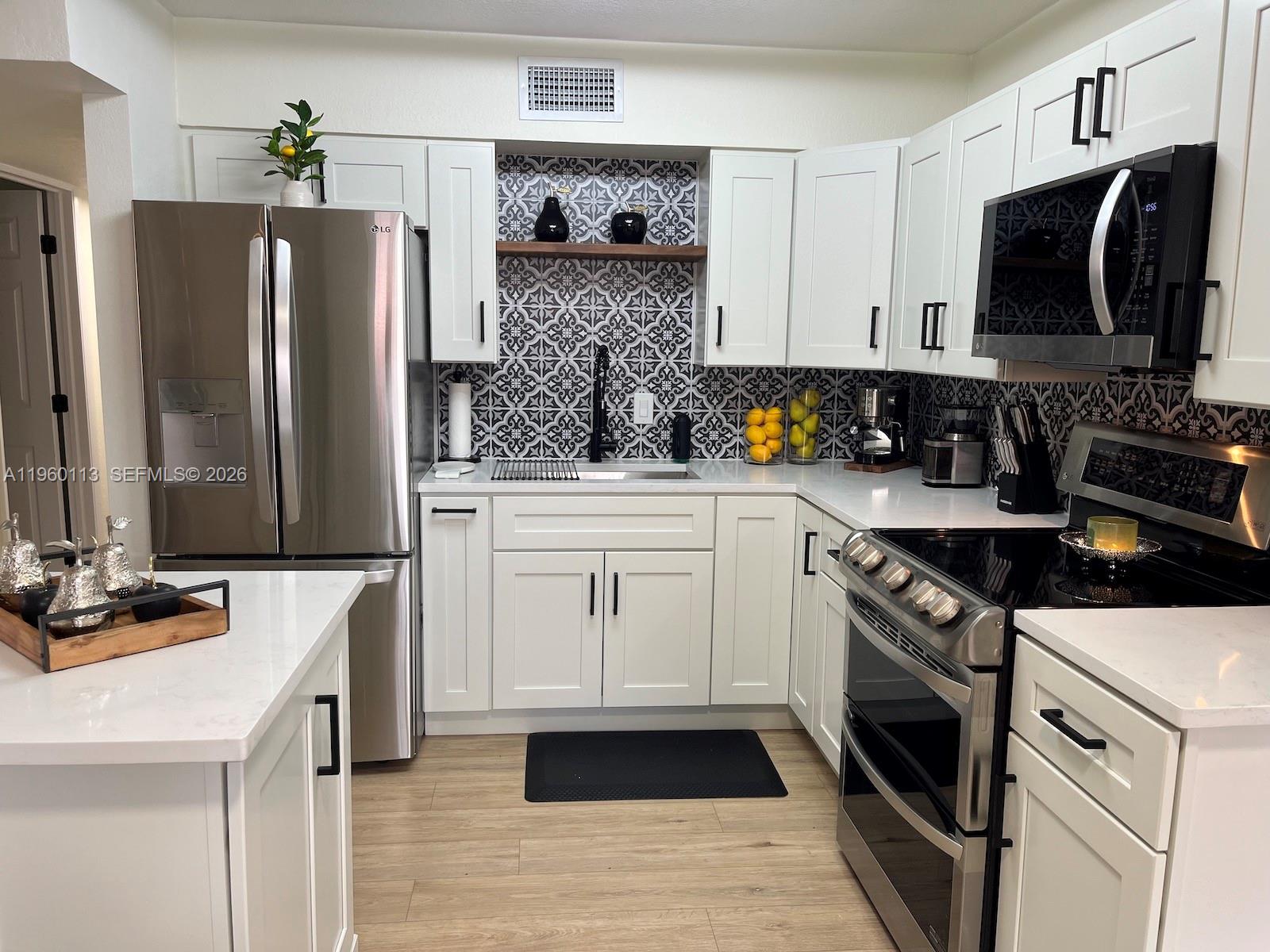 2253 Dordon Drive Melbourne, FL 32935 - Photo 20 of 40 a kitchen with stainless steel appliances a stove microwave and refrigerator
