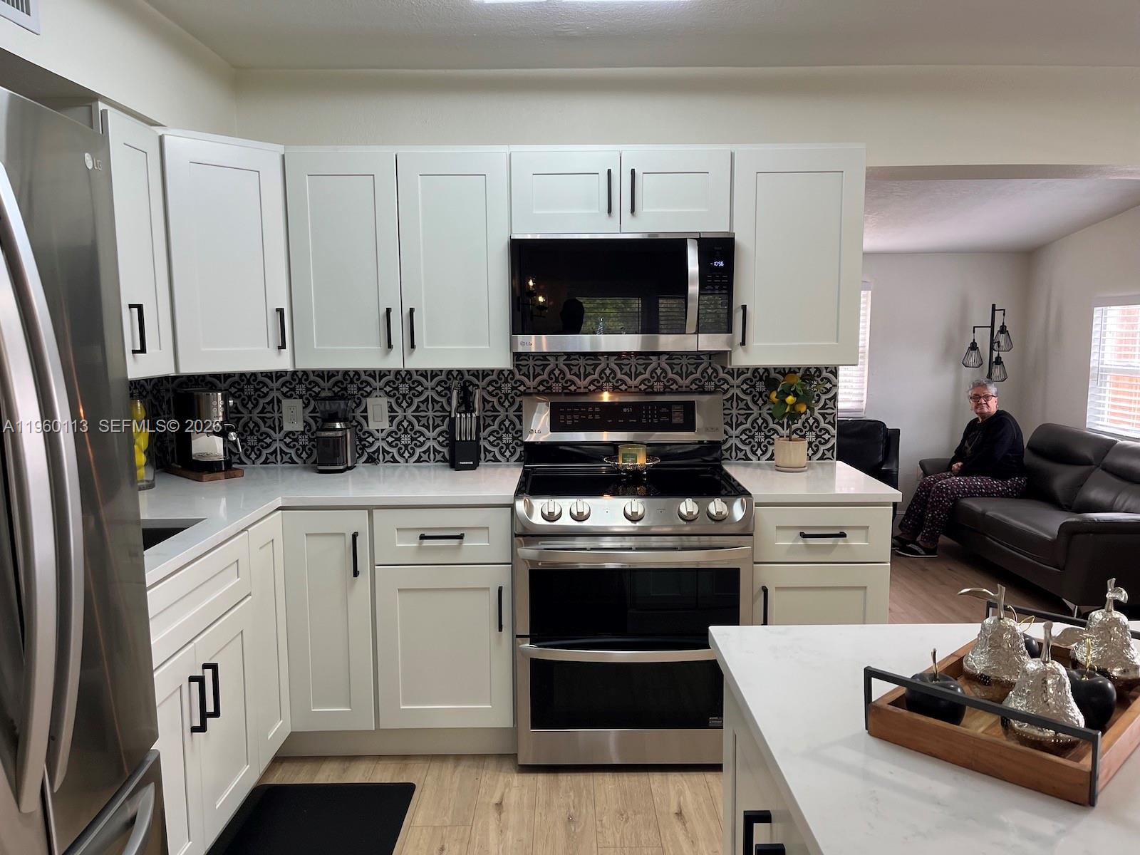 2253 Dordon Drive Melbourne, FL 32935 - Photo 21 of 40 a kitchen with stainless steel appliances white cabinets a stove a sink and a refrigerator
