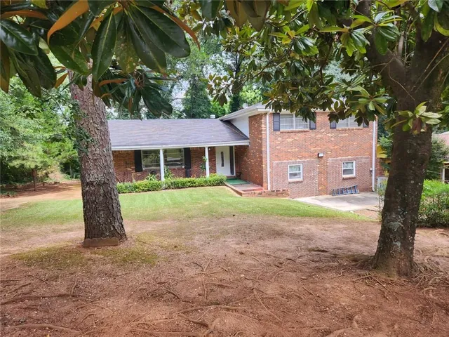 a view of a house with a tree in the yard