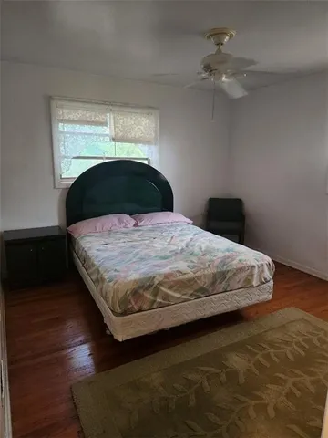 a bedroom with a bed and a ceiling fan