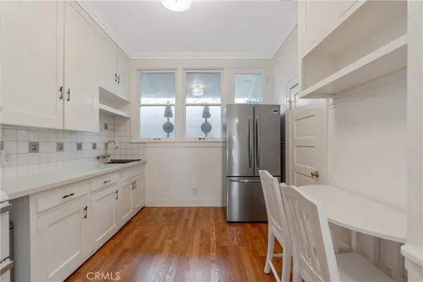 a kitchen with a refrigerator a sink and wooden floor