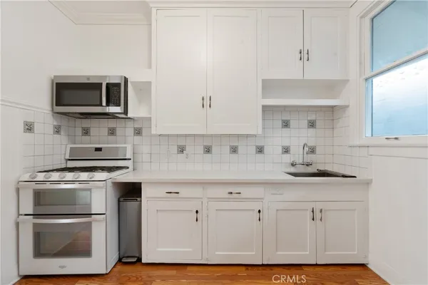 a kitchen with white cabinets stainless steel appliances and sink