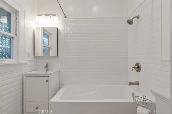 a bathroom with a sink mirror and bathtub