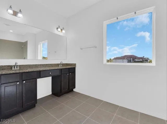 a bathroom with a granite countertop sink a mirror and a picture