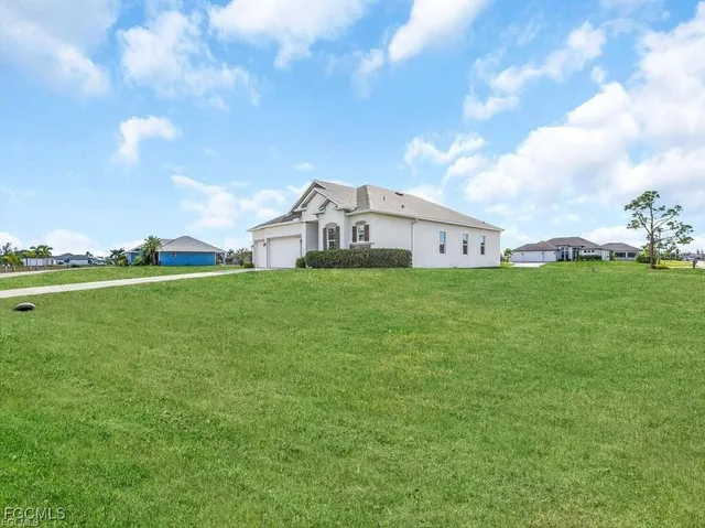 a view of a house with a big yard and large trees