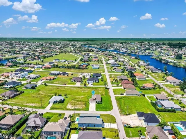 an aerial view of residential houses with outdoor space and trees