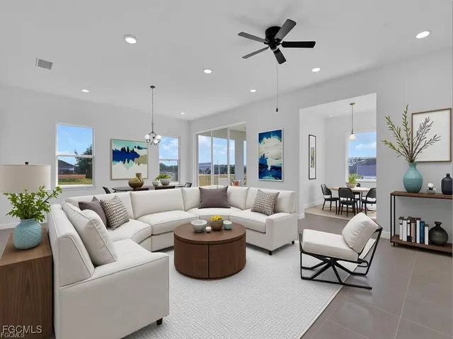 a living room with furniture kitchen view and a chandelier