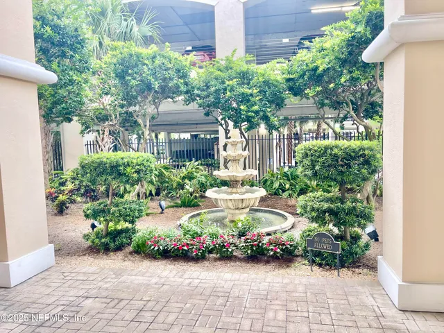 a front view of a house with a yard and potted plants