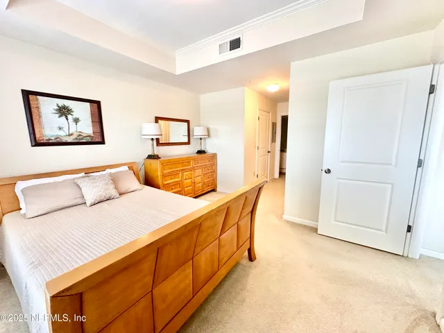 a bedroom with a bed and a lamp on dresser