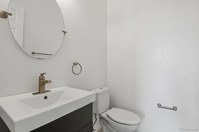 a bathroom with a toilet a sink and mirror