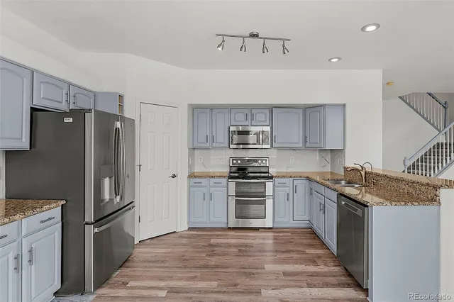 a kitchen with stainless steel appliances granite countertop a stove and a refrigerator