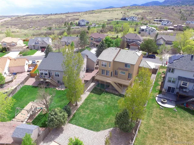 an aerial view of residential houses with outdoor space and trees
