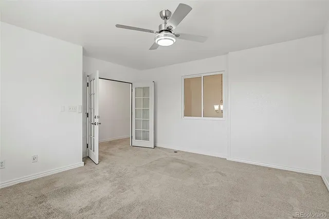 a view of an empty room with a ceiling fan