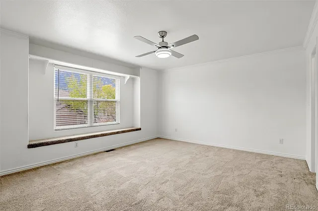 an empty room with a window and a ceiling fan