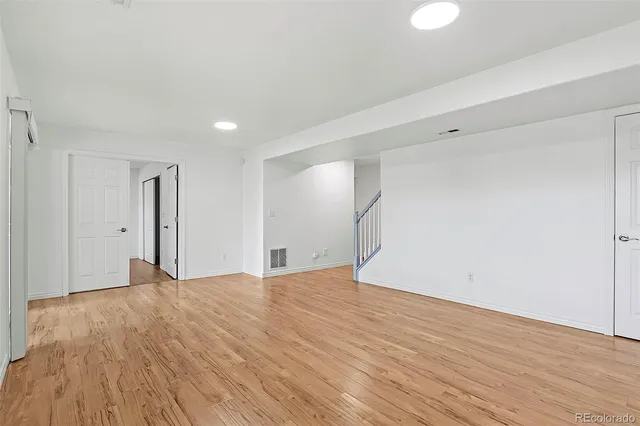 a view of an empty room with wooden floor