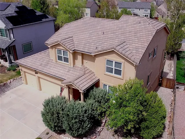 a aerial view of a house with a yard and potted plants