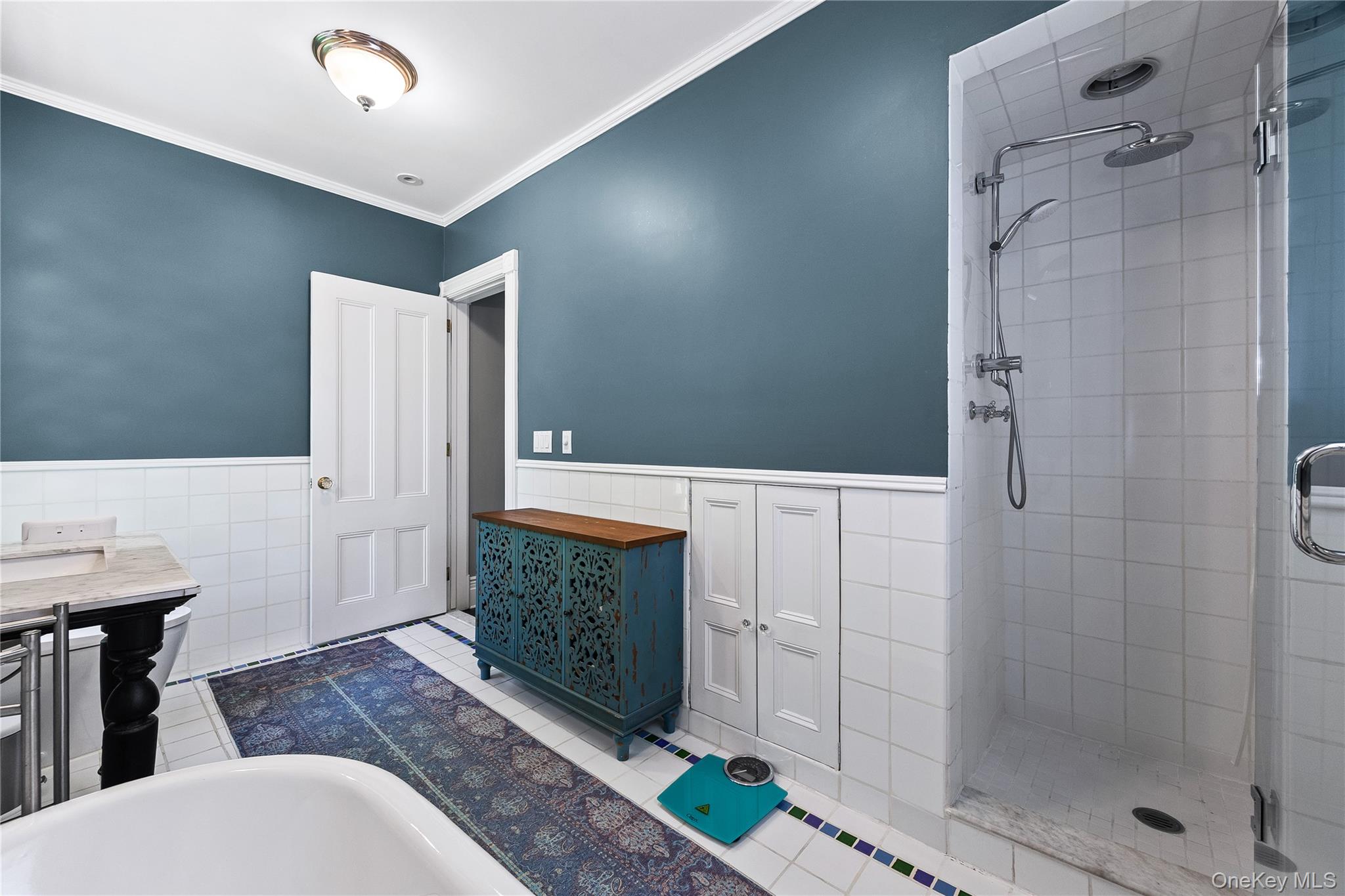 19 Howe Place Bronxville, NY 10708 - Photo 21 of 37 Bathroom featuring a large glass-enclosed shower with a rainfall showerhead, white subway tile wainscoting, and a freestanding soaking tub