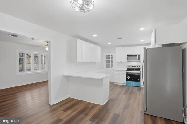 a kitchen with stainless steel appliances a refrigerator and a stove top oven