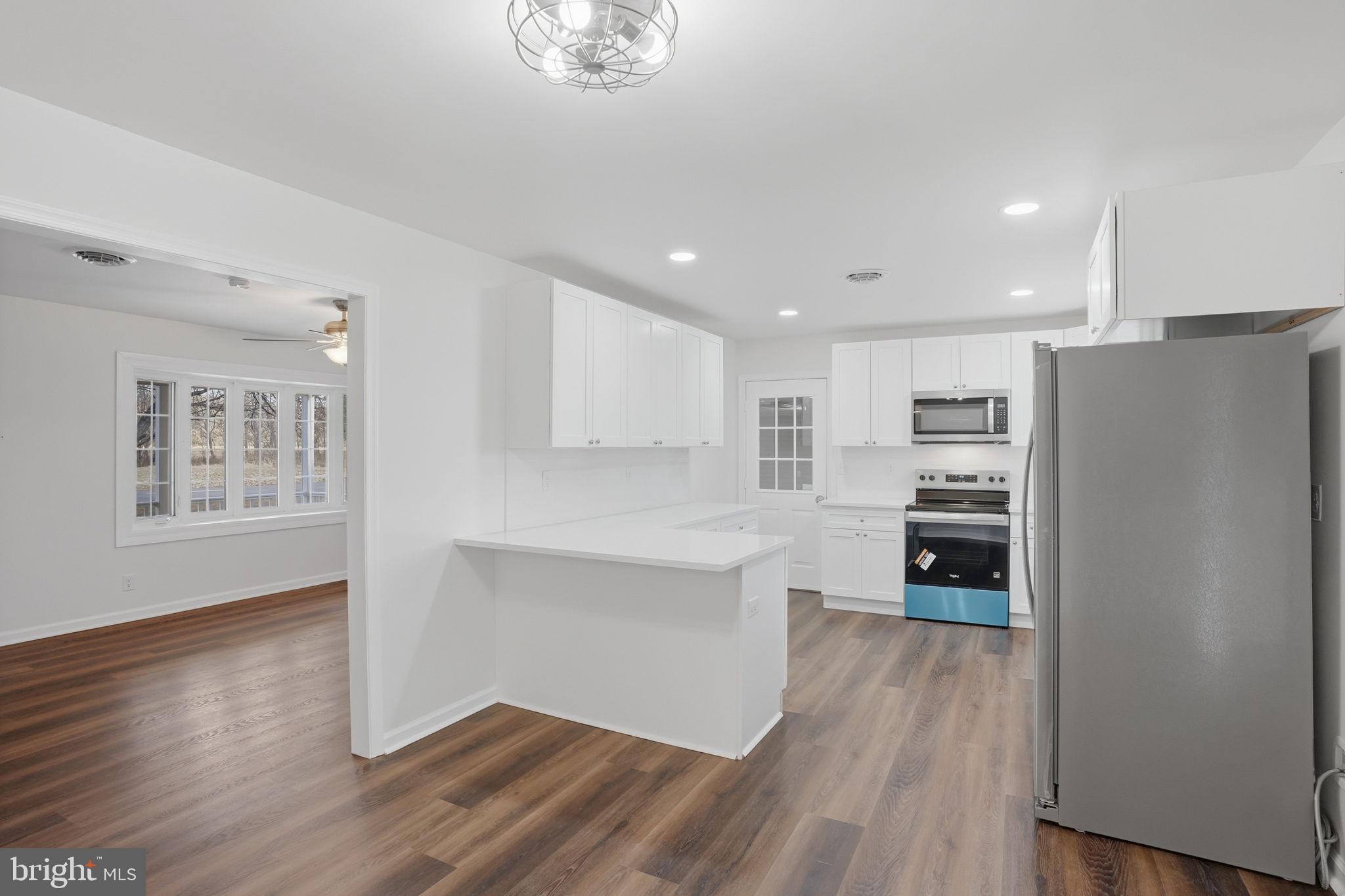1804 Hourglass Road Hartly, DE 19953 - Photo 13 of 46 a kitchen with stainless steel appliances a refrigerator and a stove top oven