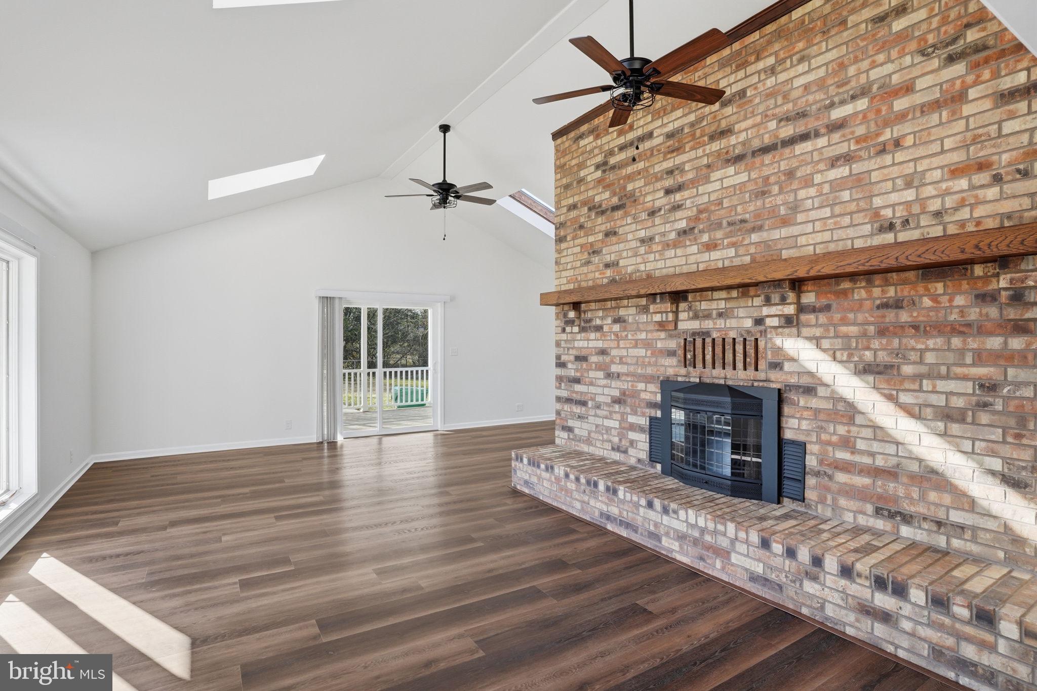 1804 Hourglass Road Hartly, DE 19953 - Photo 19 of 46 an empty room with wooden floor fireplace and windows