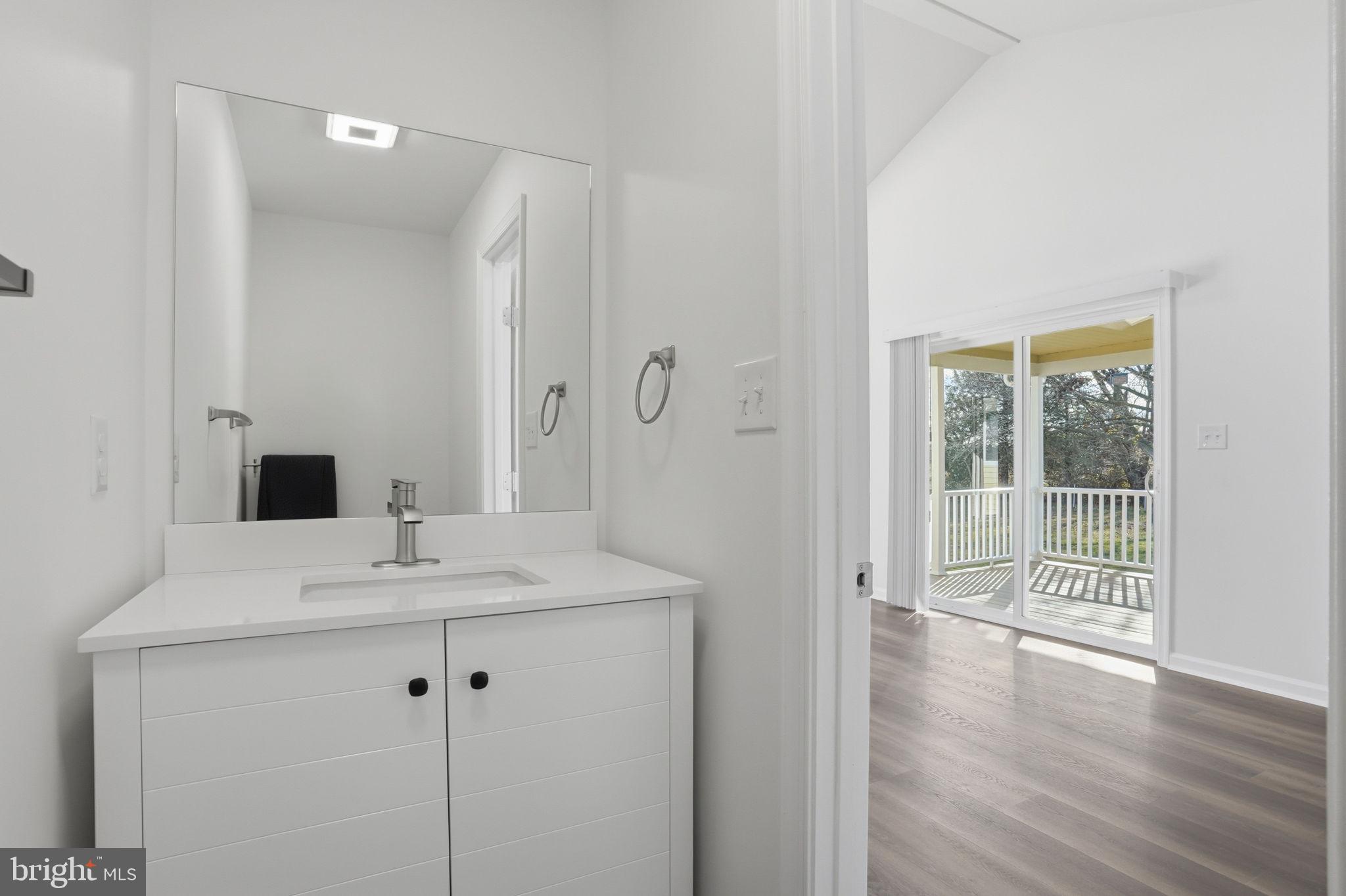 1804 Hourglass Road Hartly, DE 19953 - Photo 21 of 46 a view of a bathroom with a sink wooden floor and a mirror