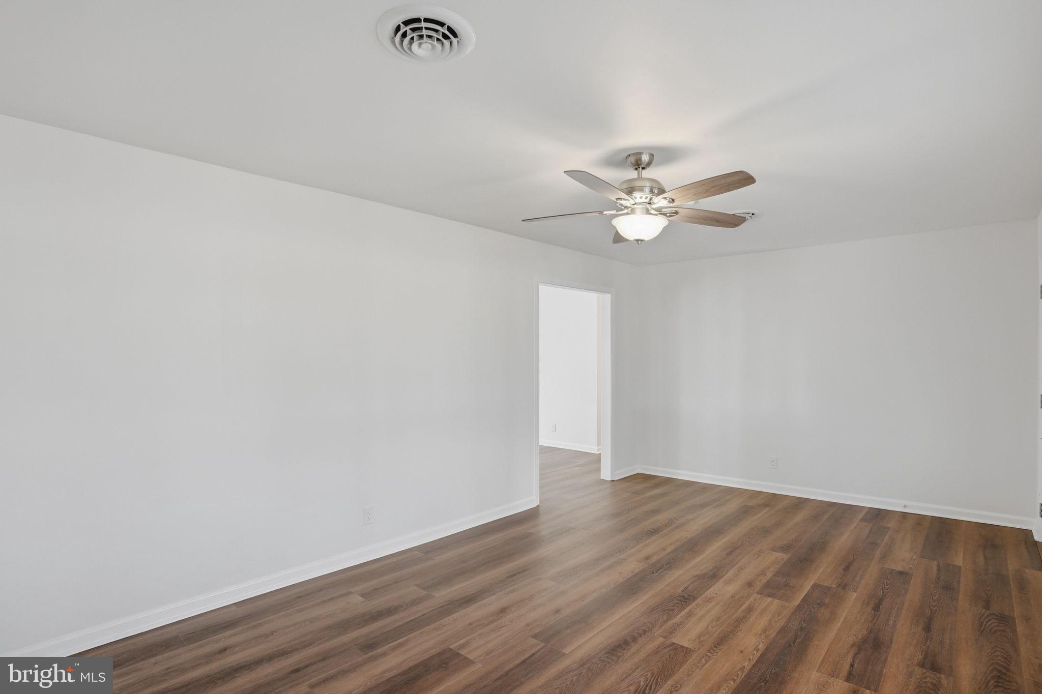 1804 Hourglass Road Hartly, DE 19953 - Photo 6 of 46 an empty room with wooden floor and ceiling fan