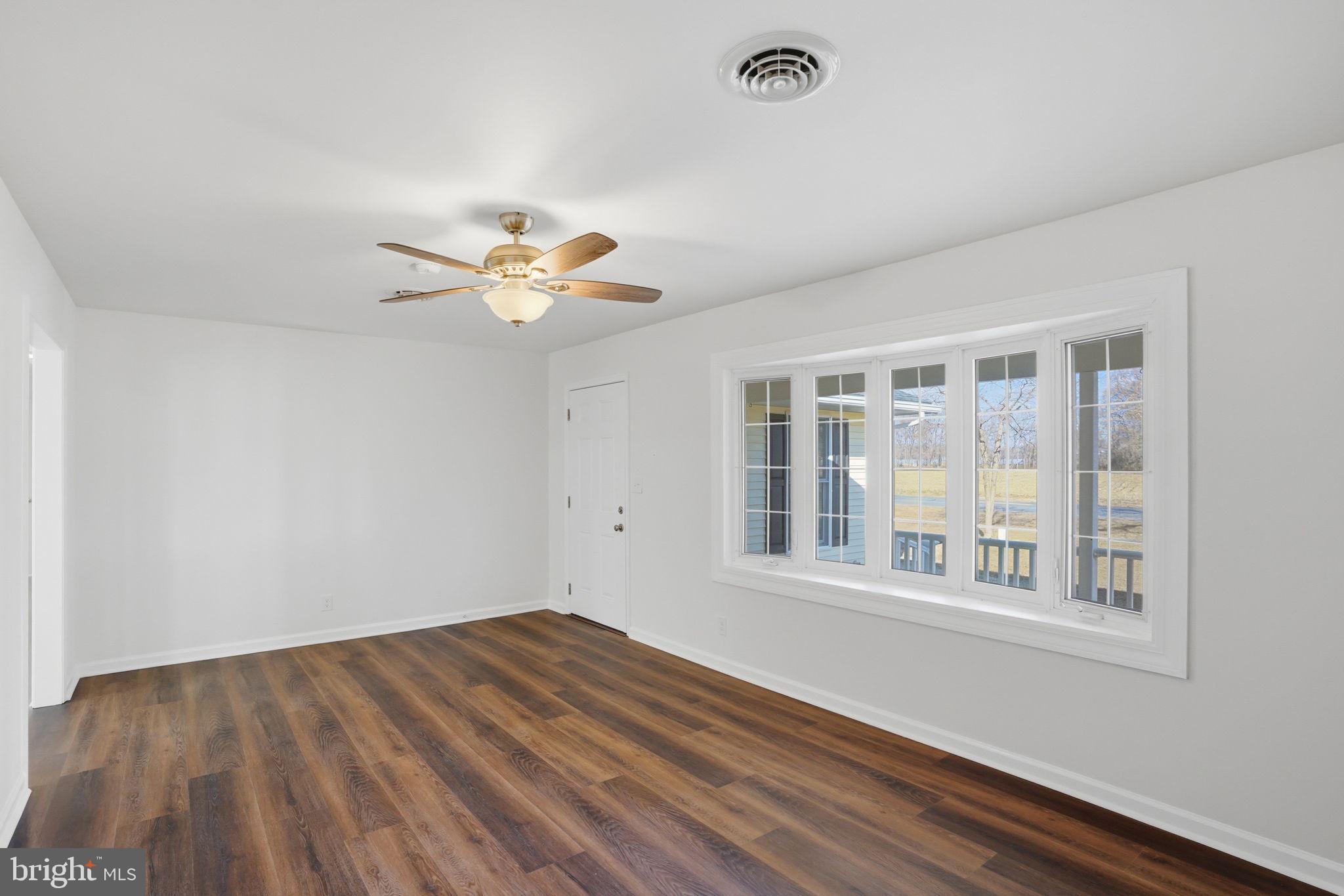 1804 Hourglass Road Hartly, DE 19953 - Photo 7 of 46 a view of an empty room with wooden floor and a window