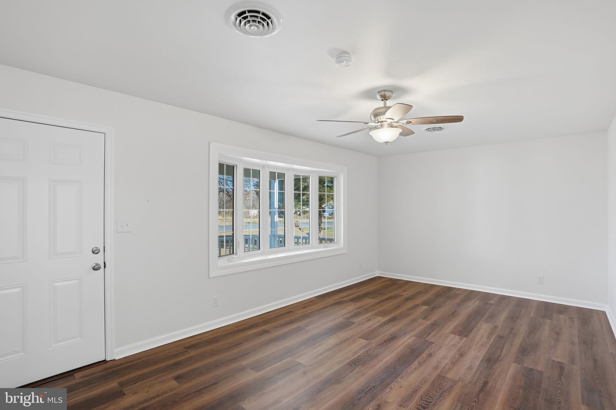 1804 Hourglass Road Hartly, DE 19953 - Photo 8 of 46 a view of an empty room with a window and wooden floor
